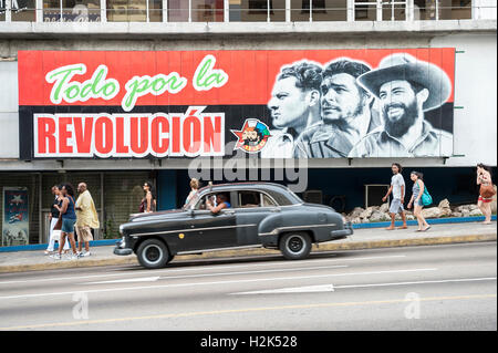 Havanna - 13. Juni 2011: Billboard kommunistische Propaganda steht über amerikanische Oldtimer vorbei unten in La Rampa zu fördern. Stockfoto