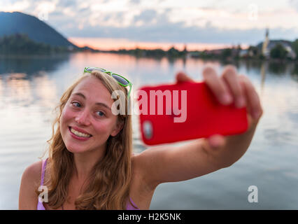 Junge Frau nimmt eine Selfie und lächelnd, Schliersee, Upper Bavaria, Bavaria, Germany Stockfoto