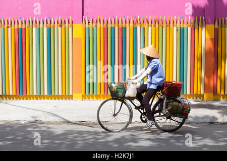 Vietnamesin mit konischen Hut, mit dem Fahrrad Stockfoto