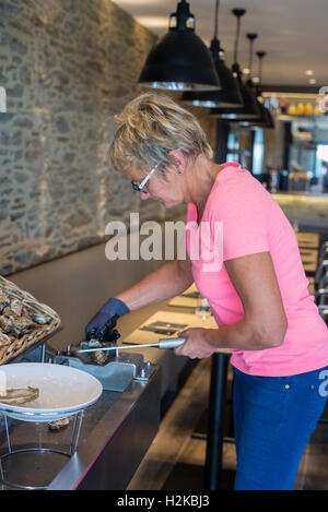Frau Vorbereitung Austern im Restaurant, Cancale, Bretagne, Frankreich, EU, Europa. Stockfoto