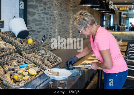 Frau Vorbereitung Austern im Restaurant, Cancale, Bretagne, Frankreich, EU, Europa. Stockfoto