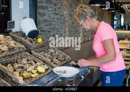 Frau Vorbereitung Austern im Restaurant, Cancale, Bretagne, Frankreich, EU, Europa. Stockfoto