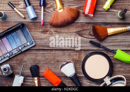 Schminkpinsel und Kosmetik auf einem hölzernen Hintergrund Stockfoto