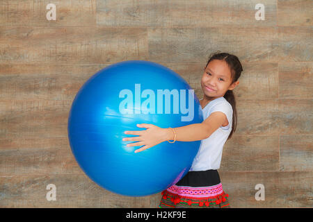 Mädchen mit blauen großen Gummiball. Stockfoto