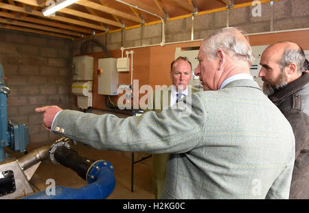 Der Prinz von Wales, auch bekannt als der Duke of Rothesay, mit leitender Projektingenieur Michael Bestwick und Estate Faktor Richard Glendson, als er das Braemar Wasserkraft Wasserkraftwerk Schema Turbinenhaus bei Linn Dee Road in Braemar öffnet. Stockfoto