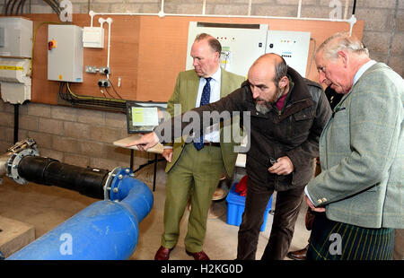 Der Prinz von Wales, auch bekannt als der Duke of Rothesay, mit leitender Projektingenieur Michael Bestwick und Estate Faktor Richard Glendson, als er das Braemar Wasserkraft Wasserkraftwerk Schema Turbinenhaus bei Linn Dee Road in Braemar öffnet. Stockfoto