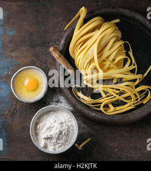 Rohe hausgemachte italienische Teigwaren Tagliatelle mit Nudeln Cutter, Schalen mit Weißmehl und gebrochene Ei in alten Ton Fach über d Stockfoto