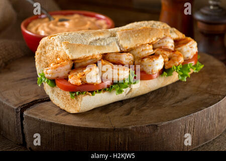 Ein lecker hausgemachten gegrillte Garnelen Po Boy Sandwich auf Baguette mit Salat, Tomate und Remoulade gekleidet. Stockfoto