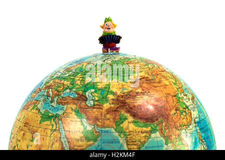 Puppe Mann spielt Ziehharmonika auf einem Globus Stockfoto