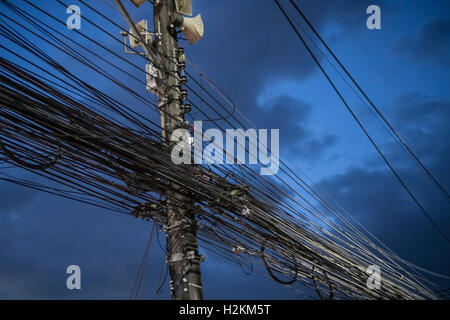 Wirren und unordentlich elektrische Kabel und Leitungen auf elektrische Pole über Abendhimmel Stockfoto