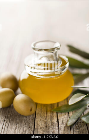 Olivenöl in eine Flasche auf einem Holztisch Stockfoto