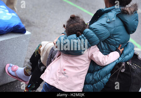 Konstanz, Deutschland. 19. Sep, 2016. Sithawit (25) aus Eritrea, die hochschwangere, Ahd ihre 4 jährige Tochter Winta, wartet hinter ein Polizist für einen Schiene Ersatz-Bus-Service, ihn zu Flüchtling Staatsempfang nehmen Zentrum in Karlsruhe, am Bahnhof in Konstanz, Deutschland, 19. September 2016. Foto: KARL-JOSEF HILDENBRAND/DPA/Alamy Live-Nachrichten Stockfoto