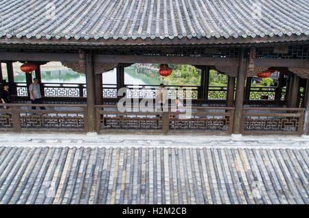 Chongqing. 29. Sep, 2016. Luftbild, aufgenommen am 29. September 2016 zeigt Touristen die gedeckte Holzbrücke über den Apeng River in Südwest-China Chongqing. Diese hölzerne Vorgängerbauten über der Brücke wurden im Jahr 2013 durch einen Brand zerstört, und die Brücke wieder eröffnet, ein Jahr später nach der Rekonstruktion. © Liu Chan/Xinhua/Alamy Live-Nachrichten Stockfoto