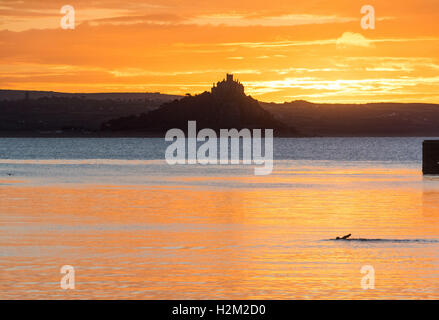 Penzance, Cornwall, UK. 30. September 2016. Großbritannien Wetter. Ein Schwimmer nimmt am frühen Morgen Sprung im Hafen von Penzance, beim Sonnenaufgang über St. Michaels Mount. Bildnachweis: Simon Maycock/Alamy Live-Nachrichten Stockfoto