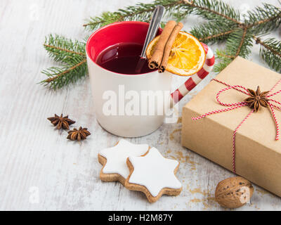 Selbst gemachter Butter Muttern Stern geformte Plätzchen mit Zuckerguss, Kiefer, Orangenscheiben, Zimt, Anis und Walnüssen in weißem Holz Hintergrund. Stockfoto