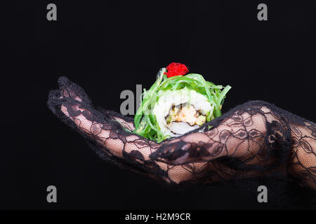 Hand hält eine bunte sushi Stockfoto