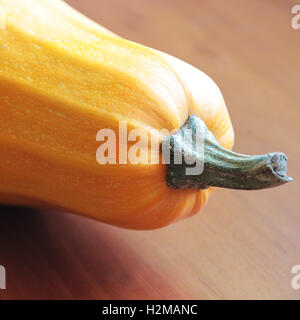 Gelber Kürbis schließen isoliert auf hölzernen Hintergrund Stockfoto