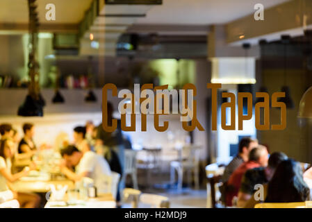 Cafe und Tapas Restaurant Schild mit unscharfen Menschen Hintergrund Stockfoto