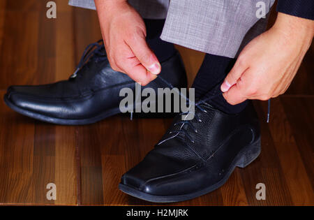 Closeup Mannes formalen schwarze Schuhe mit Händen binden der Schnürsenkel, Männer bekommen gekleidet Konzept Stockfoto