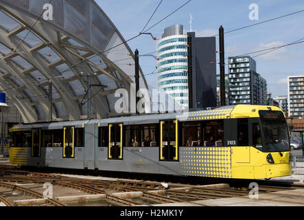 Metrolink tram verlassen Victoria Station, Stadtzentrum, Manchester, UK. Grünes Viertel Stadtumbau Gebäude darüber hinaus. Stockfoto