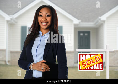 Schöne African American Real Estate Agent inf vor dem verkauften Haus Stockfoto