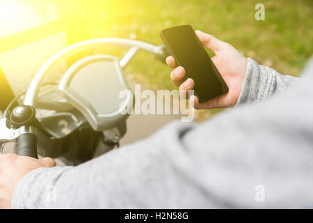 Mann fährt Fahrrad und halten Handys an Sommertag Stockfoto