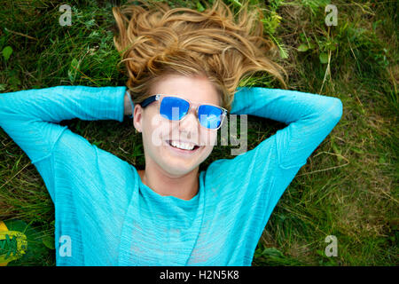 Frau in blau Jacke liegen auf dem Rasen Stockfoto