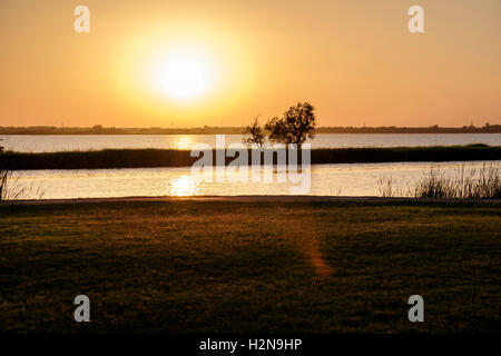 Die Sonne geht über der North Canadian River und Overholser See geteilt durch einen Deich in Oklahoma City, Oklahoma, USA. Stockfoto