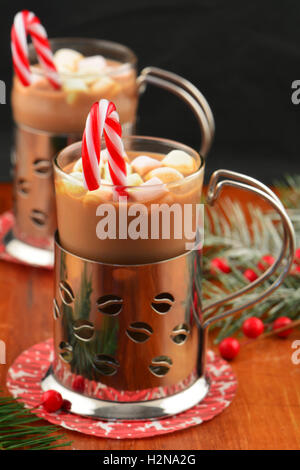 Fröhliche Weihnachten Tassen heiße Schokolade mit Mini Marshmallows und Pfefferminz Zuckerstangen auf dunklem Hintergrund mit Platz für Ihre t Stockfoto