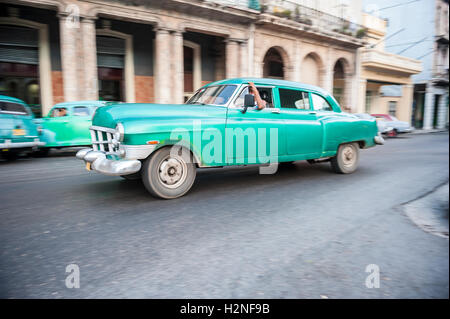 Havanna - 15. Juni 2011: Alte amerikanische Auto fährt vor der traditionellen Architektur der kolonialen Arcade am Paseo del Prado Stockfoto