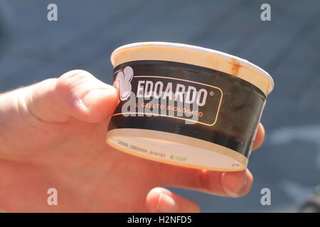 Nahaufnahme von einer Hand hält einen leeren italienische Bio-Eis-Topf Stockfoto