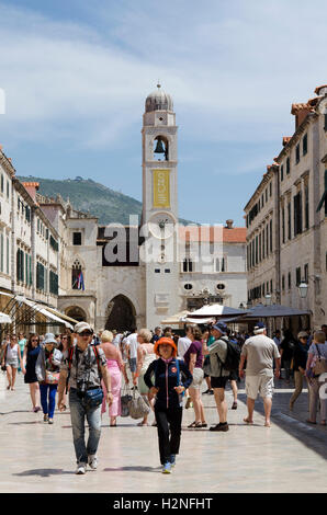 Dubrovnik Kroatien Touristen Fuß entlang der Stradun mit Glockenturm aus dem 15. Jahrhundert im Hintergrund Stockfoto