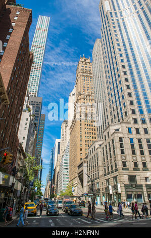 NEW YORK CITY - 3. September 2016: Verkehr baut als Fußgänger überqueren 57th Street in Midtown Manhattan unter Wolkenkratzern. Stockfoto