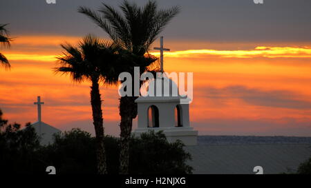 Silhouette der Dattelpalmen neben der Kirche bei Sonnenaufgang in Süd-Kalifornien Stockfoto