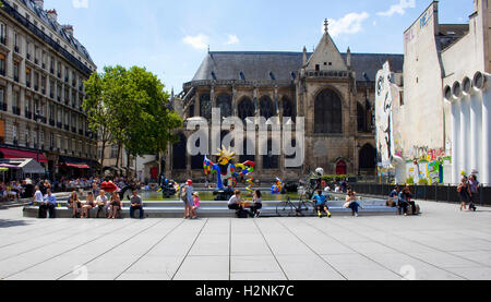 Menschen sitzen um Stravinsky-Brunnen und genießen Sie sonnige Tage in Paris. Es gibt viele zeitgenössische Kunstwerke in den Pool. Stockfoto