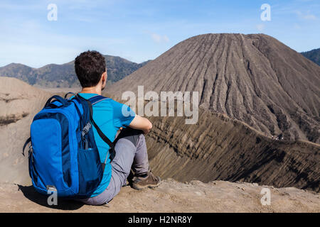 Jungen männlichen Erwachsenen Reisenden beobachten den Krater und die Caldera des aktiven Vulkans Bromo, Ost-Java, Indonesien Stockfoto