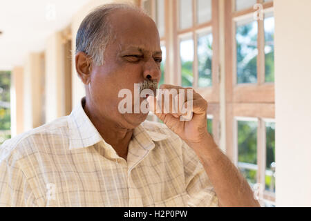 Closeup Portrait, Greis, Husten mit Post nasal Drip Bug, wirklich krank bei schlechtem Wetter halten Faust in den Mund, isoliert im freien Stockfoto