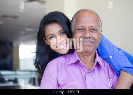 Closeup Portrait, Familie, junge Frau im blauen Hemd älteren Mann in rosa Kragen-Taste gedrückt halten von hinten glücklich isoliert Stockfoto