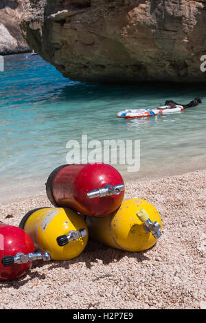 Bunte Sauerstoff-Tauchflaschen für Taucher an einem Strand Stockfoto