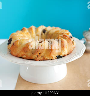 Kuchen-Kouglof auf einem weißen Teller Türkis Hintergrund Stockfoto