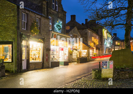 Bunte Weihnachtslichter erhellen eines dunklen Winters Abend - Grassington Dorf, Yorkshire Dales National Park, England. Stockfoto