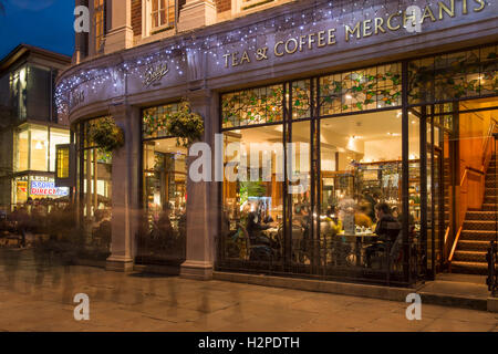 Äußere Abendlicher Blick von Betty's Café Teestube an Weihnachten, Diners am Fenster sitzt, in warmes Licht getaucht - York, North Yorkshire, England, UK. Stockfoto