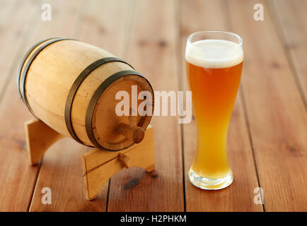 Nahaufnahme von Bierglas und Holzfass auf Tisch Stockfoto