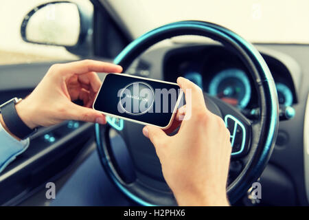 Hände mit Navigator auf Smartphone im Auto Stockfoto