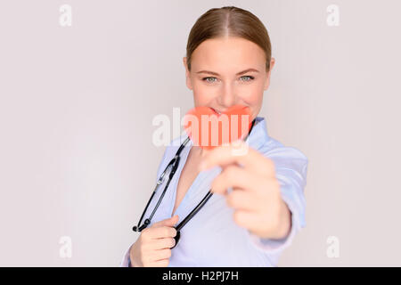 Porträt eines glücklichen Kardiologe Arztes zeigt konzeptionelle Papierherz, erfolgreiche Transplantation, guter Facharzt Stockfoto