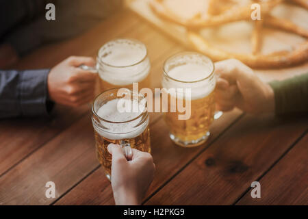 Nahaufnahme von Händen mit Bierkrügen in Bar oder Kneipe Stockfoto