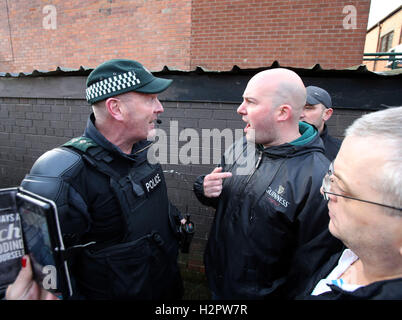 Damien 'Dee' Fennell, ein Sprecher des Greater Ardoyne Residents' Collective (Garc), argumentiert mit einem Polizeibeamten, nachdem eine Parade der Orange Order entlang der Crumlin Road neben dem nationalistischen Ardoyne-Distrikt im Norden von Belfast passiert war. Stockfoto