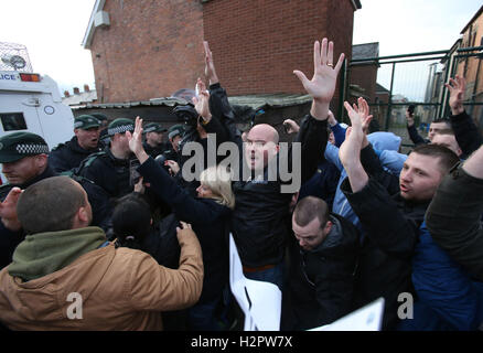 Damien "Dee" Fennell (Mitte), ein Sprecher für die größere Ardoyne Residents Kollektiv (GAERC), ruft zur Ruhe als Orange Auftrag Parade entlang der Crumlin Road neben dem nationalistischen Ardoyne im Stadtteil North Belfast führt. Stockfoto