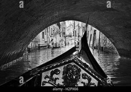 schwarz weiß Ansicht von innen Gondel in Venedig, die endlose Stadt Brücken auf viel befahrenen touristischen Wasserweg Unterquerung Stockfoto