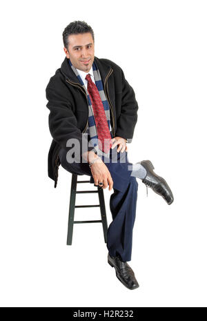 Ein junger Geschäftsmann auf einem Stuhl sitzend und auf der Suche für weißen Hintergrund entspannt. Stockfoto